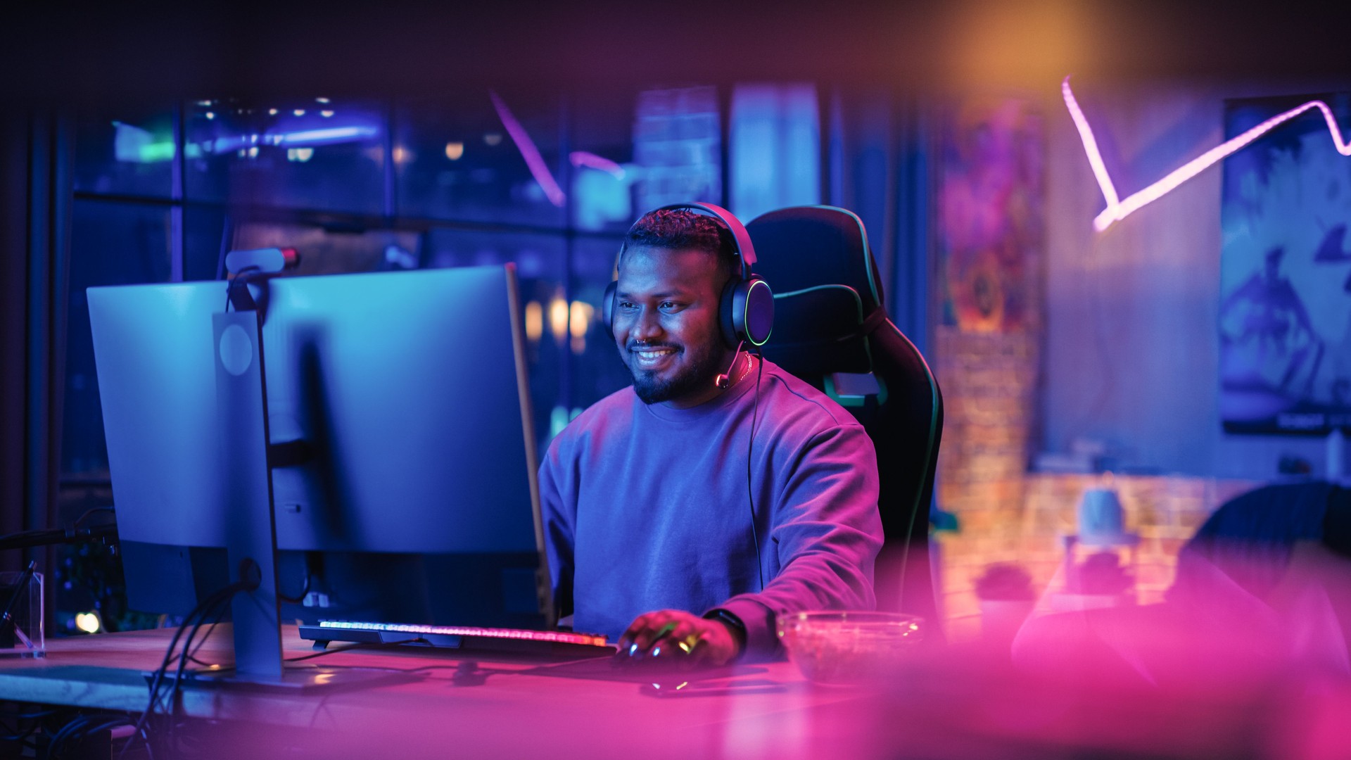 Gaming from Home: Portrait d’un joueur portant des écouteurs et jouant à un jeu vidéo compétitif sur un ordinateur personnel. Joueur professionnel élégant appréciant le tournoi PvP multijoueur en ligne.
